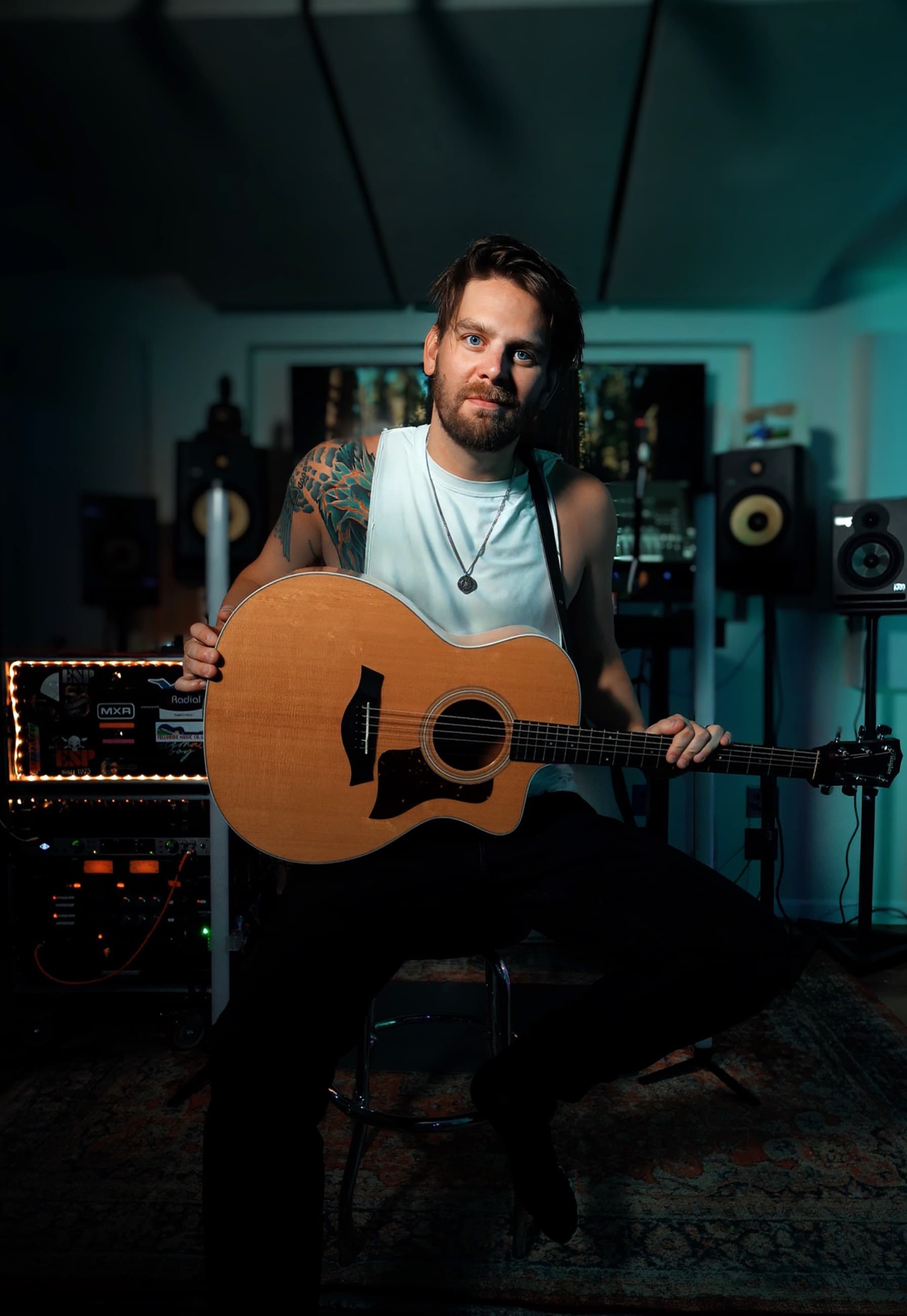 Matt Winwood seated with an acoustic guitar in his Pittsburgh home studio